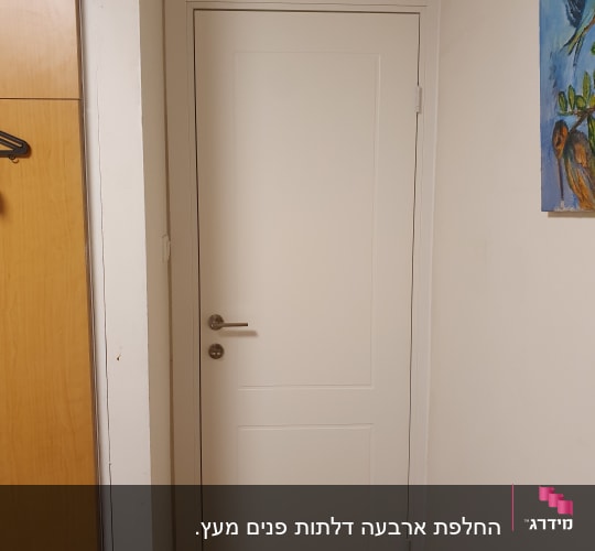 דלת לבנה בחדר עם קיר ותמונה